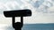 Binoculars on observation deck on background of sea. Concept. Black modern binoculars for viewing territory on coast