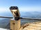 Binoculars on an observation deck made of gray metal. sightseeing tour, observation of the view from the mountains down. next to