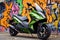 biofuel powered motorbike parked against a graffiti wall
