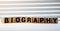 Biography headline sign made of wood on a table