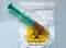 Biohazard specimen bag with a syringe and brown liquid