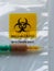 Biohazard specimen bag with a syringe and brown liquid