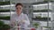 biological research laboratory, woman scientist examines plant in test tube for natural seedlings and writes observation