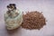 Biologically grown organic buckwheat in a burlap bag with a wooden scoop on a brown background