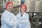 Biologist team talking and wearing hairnet in factory