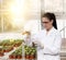 Biologist with test tube in greenhouse