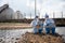 Biologist wear protective suit and mask collects sample of waste water from industry