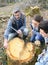 Biology professor with students analysing tree trunk using tablet