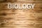 BIOLOGY word made of wooden block letters on wooden board.