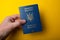 Biometric Ukrainian passport in hand on a yellow background