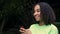 Biracial African American girl teenager young woman outside using her smart cell phone for social media or texting