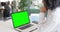 Biracial businesswoman watching laptop with green screen in office, slow motion