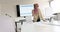 Biracial casual businesswoman in hijab using notes and tablet in meeting room, slow motion