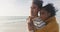 Biracial couple embraces on a serene beach