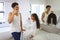 Biracial father and daughter brushing teeth together in bathroom at morning