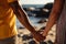 Biracial gay couples hands embrace on a sunlit beach together