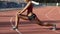 Biracial lady stretching and warming up her leg muscles before starting to run