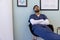 Biracial male doctor taking nap in hospital waiting room
