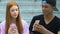 Biracial male teen showing smartphone app to beautiful friend, gadget addiction