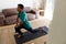 Biracial man exercising and stretching on mat at home