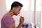 Biracial man looking in mirror and brushing teeth in bathroom