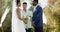 Biracial man officiating wedding ceremony for african american couple in garden, in slow motion