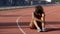 Biracial sportswoman exhausted after tough trainings sitting in middle of track