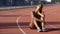 Biracial sportswoman sitting tired after trainings in middle of track, exhausted