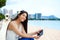 Biracial teen girl on beach using tablet computer, Waikiki, Honolulu