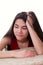 Biracial teen girl in red dress looking bored or tired, leaning