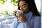 Biracial woman drinking coffee at sunny home