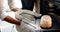 Biracial woman wearing apron and baking bread in kitchen, slow motion