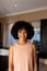 Biracial young woman standing indoors, smiling at camera at home