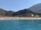 Birch, clear sea and mountains on the horizon. An ideal place for a seaside holiday. In the distance, a Mediterranean beach, view