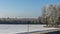 Birch trees in hoarfrost in winter daytime. Snow covered field, some bare deciduous trees, blue sky. Nature background.