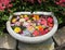 Bird bath with various summer flower blooms floating in water