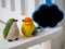 Bird dolls made of stucco on white chair background with small board cloud