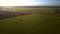 Bird eye flight over pictorial landscape with fields at sunset