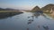 Bird eye flight river with boats against hilltops and bridge