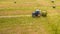 Bird eye of Man at work on the tractor with hay baler