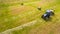 Bird eye of Man at work on the tractor with hay baler