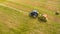 Bird eye of Man at work on the tractor with hay baler