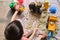 Bird eye view of toddler boy playing with kinetic sand at home, Child playing with toy construction machinery, Creative play for