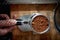 Bird-eye view of a utensil full of ground coffee ready for making an espresso. Coffee, beverage, bar