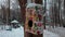 bird feeder from a colored gift box hanging on a tree in a park in winter