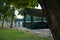 A bird feeder hangs from a tree that is located next to the horse yard