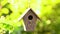 Bird house hanging in a tree in a garden during summer