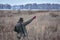 The bird hunter walks across the field with his dog on a partridge hunt and shows her where to go