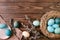 Bird nest with turquoise easter eggs and willow branch on wooden desk