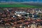 Bird`s eye view of city in Romania with green fields and foothills in the background